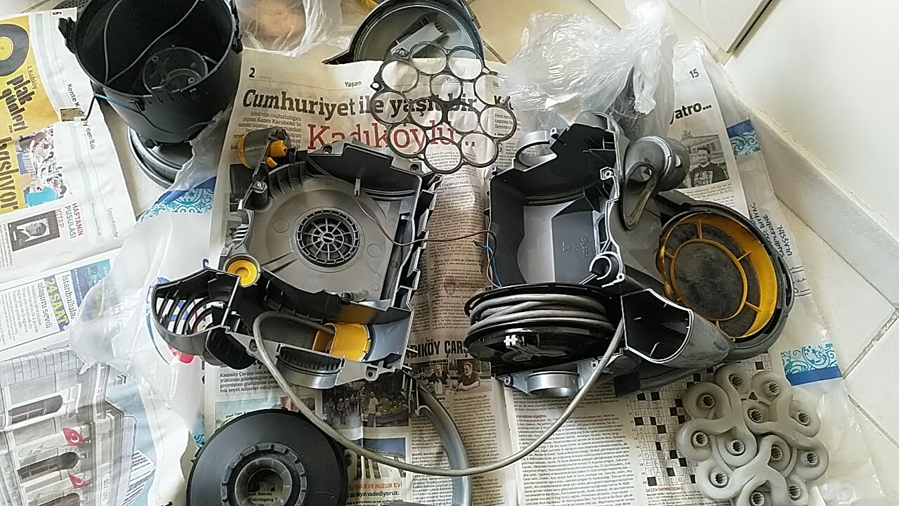A Dyson hoover took apart on a newspaper.
