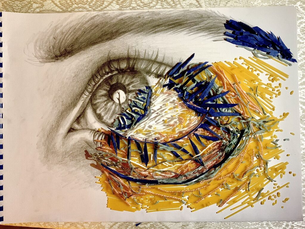 On a A3 sized paper there is a half of an eye sketched and other half of the eye constructed with the use different sizes of spagetti, blue flower petals, white and yellow thread.